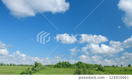 Tranquil and Beautiful Green Hills Under a Bright Blue Sky with Fluffy White Clouds Tranquil and Beautiful Green Hills Under a Bright Blue Sky with Fluffy White Clouds 128910061