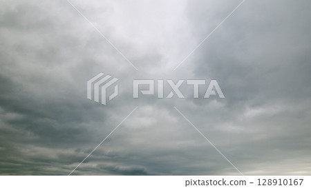 The landscape is dominated by a cloudy sky and an overcast atmosphere that captivates 128910167