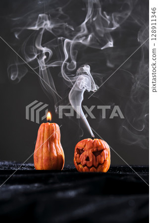 Halloween-style candles on a dark background. Festive decor. 128911346