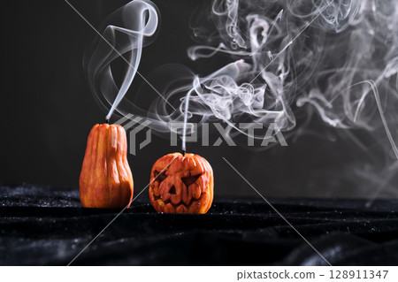 Halloween-style candles on a dark background. Festive decor. Halloween-style candles on a dark background. Festive decor. 128911347