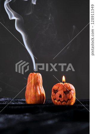 Halloween-style candles on a dark background. Festive decor. 128911349