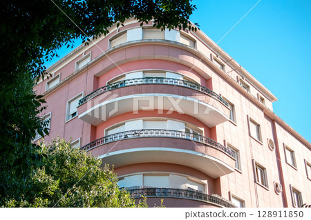 Elegant Pink Art Deco Apartment Building with Curved Balconies Elegant Pink Art Deco Apartment Building with Curved Balconies 128911850