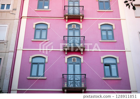 Vibrant Pink Facade with Balconies and Windows Vibrant Pink Facade with Balconies and Windows 128911851