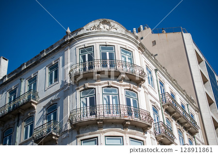 Elegant apartment building with balconies against a clear blue sky Elegant apartment building with balconies against a clear blue sky 128911861