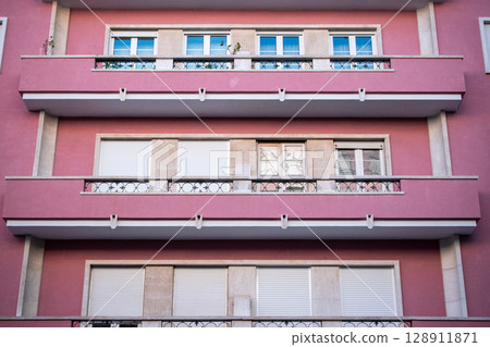 Residential Building Facade with Balconies and Windows 128911871