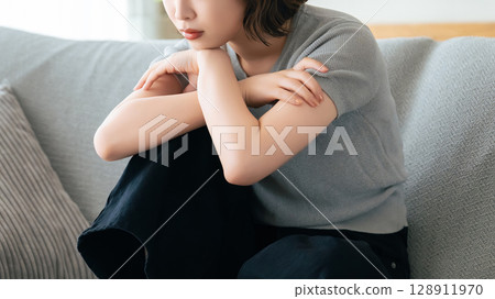 女人坐在客廳的沙發上思考 128911970