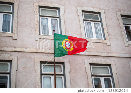 Portuguese flag waving in front of a building 128912014