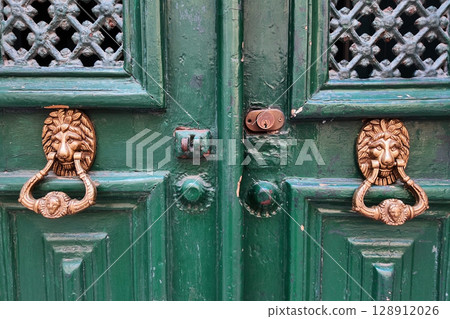 Green Door with Lion Head Knockers and Ornate Metalwork Green Door with Lion Head Knockers and Ornate Metalwork 128912026