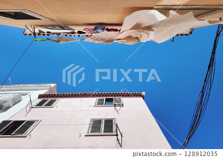 Weathered building facade with clothes drying Weathered building facade with clothes drying 128912035