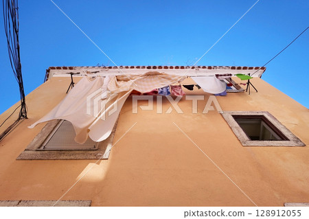 Looking Up Laundry and Buildings Against a Vibrant Blue Sky 128912055