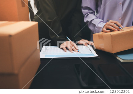 Portrait of Starting small businesses SME owners, two Asian woman check online orders Selling products working with boxs freelance work at home office, sme business online small medium enterprise Portrait of Starting small businesses SME owners, two Asian woman check online orders Selling products working with boxs freelance work at home office, sme business online small medium enterprise 128912201