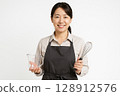 A mid-career female cooking instructor and cooking utensils 128912576