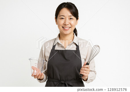 A mid-career female cooking instructor and cooking utensils 128912576