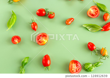 Cherry tomatoes and basil leaves on soft green background 128912639