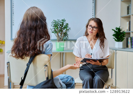 Woman school psychologist, teacher, social worker, mentor working with teenage girl Woman school psychologist, teacher, social worker, mentor working with teenage girl 128913622