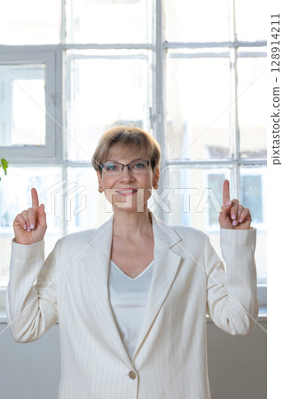 Portrait of emotional woman. Confident woman showing direction with hand. Looking at camera, banner. Vertical photo. High quality photo Portrait of emotional woman. Confident woman showing direction with hand. Looking at camera, banner. Vertical photo. High quality photo 128914211