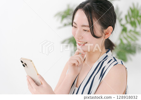A woman watching a smartphone A woman watching a smartphone 128918032
