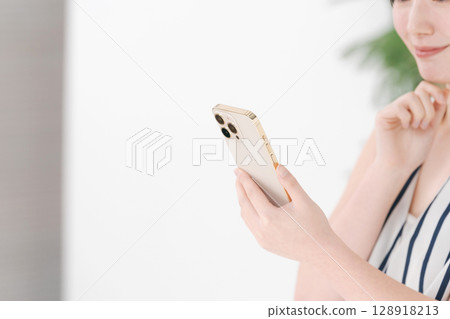 A woman watching a smartphone A woman watching a smartphone 128918213