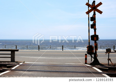 A railroad crossing in front of Kenshoji Temple on the Enoshima Electric Railway overlooking the sea (Shichirigahama 1-chome, Kamakura City, Kanagawa Prefecture) 128918593
