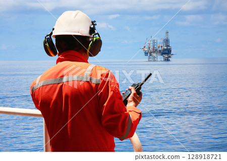 Technician monitor and command by radio to operator on job site in oil and gas industry, Worker in oil and gas industry contact to operation team to check condition of the machine, Maintenance work. 128918721