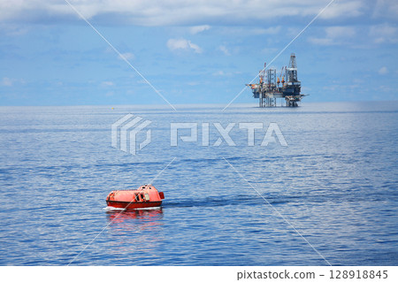 Life boat in gulf or sea to support oil and gas platform, Safety equipment to protect worker when fire case in oil and gas industry, Evacuation equipment in and and gas platform, Safety equipment Life boat in gulf or sea to support oil and gas platform, Safety equipment to protect worker when fire case in oil and gas industry, Evacuation equipment in and and gas platform, Safety equipment 128918845