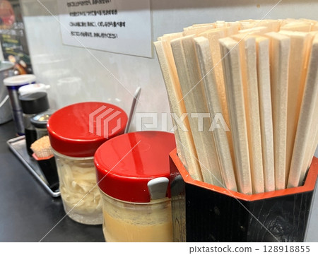 Ramen shop counter seats, chopsticks and condiments 128918855