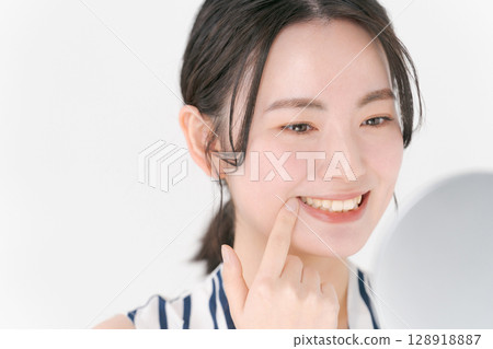 Woman looking in the mirror 128918887