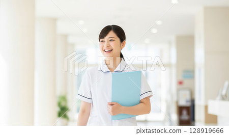 Asian nurse walking through hospital lobby Asian nurse walking through hospital lobby 128919666