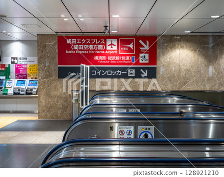 通往成田特快出發和到達月台的自動扶梯和標誌（JR東京站） 128921210