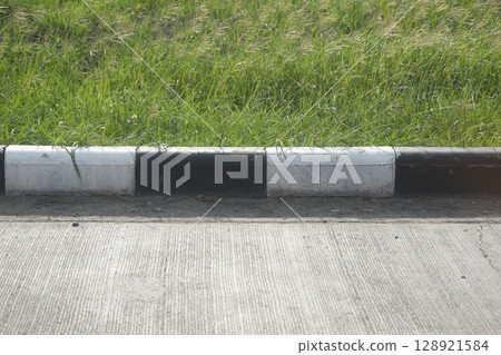 black and white curb road cement texture with green grass 128921584