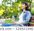 公園長椅上喝水的女人 128921946