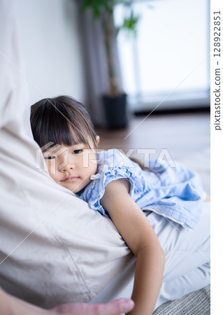 Daughter being held by her father because she is tired 128922851