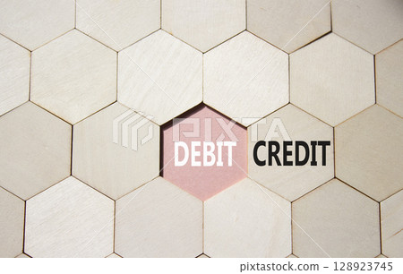 Debit or Credit symbol. Concept word Debit or Credit on wooden comb puzzle. Beautiful pink background. Business and Debit or Credit concept. Copy space Debit or Credit symbol. Concept word Debit or Credit on wooden comb puzzle. Beautiful pink background. Business and Debit or Credit concept. Copy space 128923745