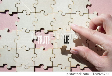 Truth or Lie symbol. Concept word Truth or Lie on wooden puzzle. Businessman hand. Beautiful pink background. Business and Truth or Lie concept. Copy space 128923782