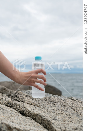 拿著塑膠瓶水的人 128924767