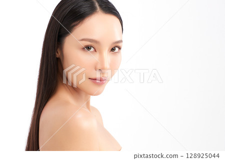 A beautiful young Asian woman with clean, fresh skin against a white background. Skincare, facial treatment, cosmetology, beauty, and spa. An elegant portrait of an Asian woman. 128925044