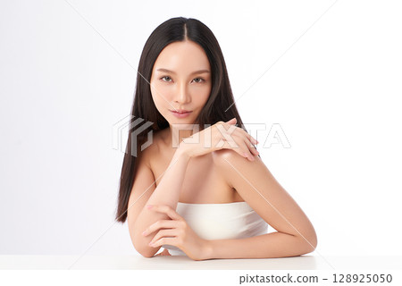 A beautiful young Asian woman with clean, fresh skin against a white background. Skincare, facial treatment, cosmetology, beauty, and spa. An elegant portrait of an Asian woman. A beautiful young Asian woman with clean, fresh skin against a white background. Skincare, facial treatment, cosmetology, beauty, and spa. An elegant portrait of an Asian woman. 128925050