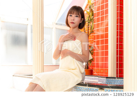 A woman in the bathroom wrapped in a bath towel A woman in the bathroom wrapped in a bath towel 128925129
