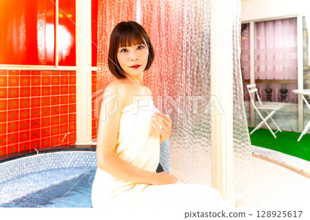 A woman in the bathroom wrapped in a bath towel A woman in the bathroom wrapped in a bath towel 128925617
