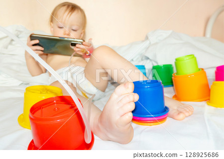child in hospital lying in bed with mobile phone smiling child in hospital lying in bed with mobile phone smiling 128925686