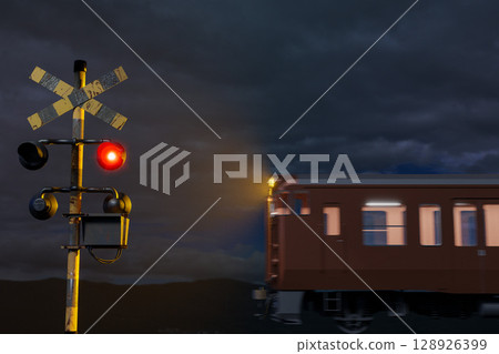 Image of a train passing through a railroad crossing at night with its alarm lit 128926399
