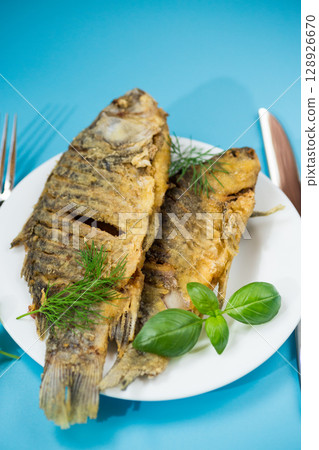Delicious juicy crucian carp with an appetizing crust, served for dinner 128926670