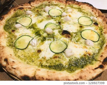 Oven-baked pizza with pesto sauce and zucchini Oven-baked pizza with pesto sauce and zucchini 128927399