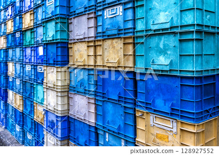 Stack of colorful plastic industrial crates arranged in a grid pattern for storage or transport use Stack of colorful plastic industrial crates arranged in a grid pattern for storage or transport use 128927552