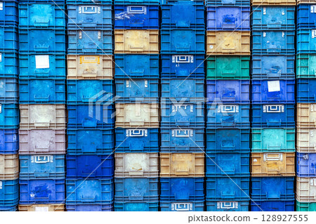 Stack of colorful plastic industrial crates arranged in a grid pattern for storage or transport use Stack of colorful plastic industrial crates arranged in a grid pattern for storage or transport use 128927555