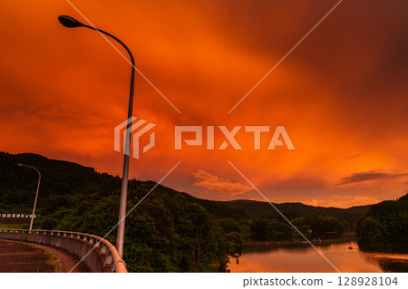 2025 Nara Nunome Dam east sky dyed orange in sunset Orange-colored dam and lake surface③ 128928104