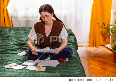 Caucasian woman reviewing financial reports planning economic strategies and balancing household budget. concept of financial independence and wealth strategy. Mid shot 128928913