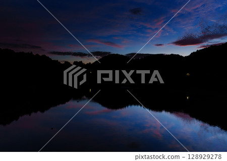 Beautiful sunset at Nunome Dam in Nara in the summer of 2025. Sunset clouds floating in the blue moment sky. Sky above Nunome Lake ⑤ 128929278