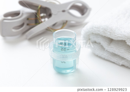 Laundry detergent and towels on white background 128929923