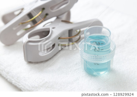 Laundry detergent and towels on white background 128929924